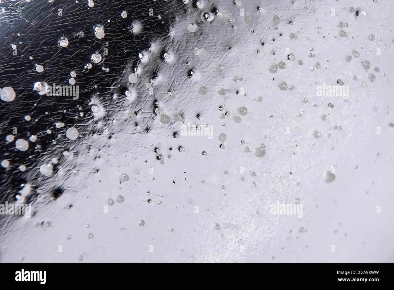 Drops and bubbles on a shiny glossy black porcelain surface