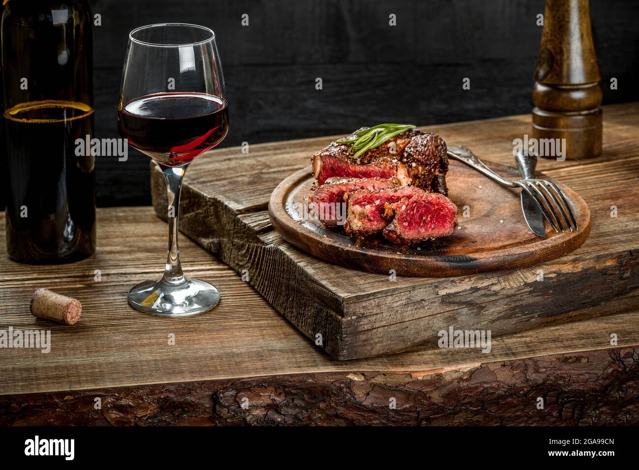 Grilled ribeye beef steak with red wine, herbs and spices on wooden ...