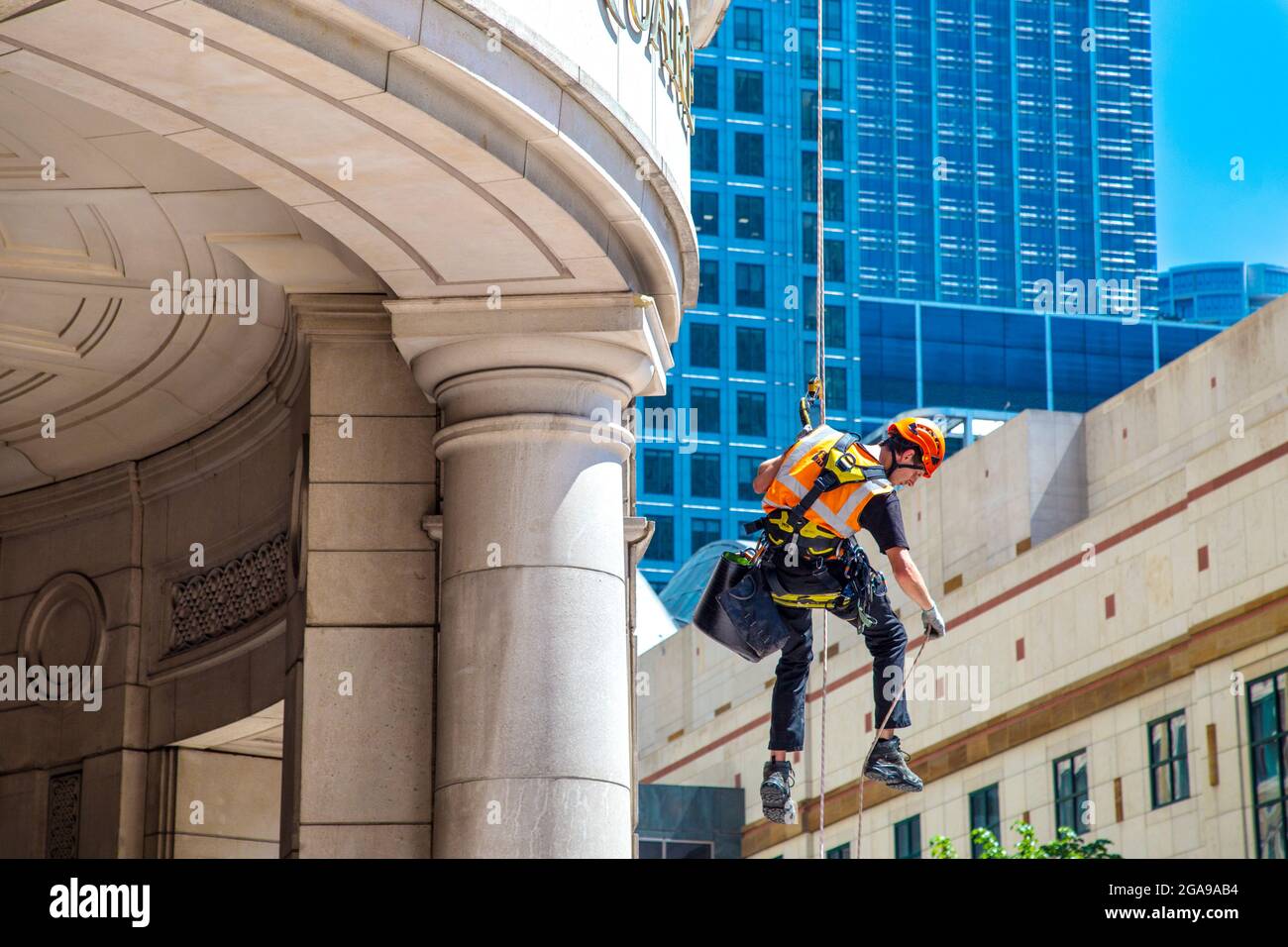 Cleaners abseiling from a contemporary glass skyscraper cleaning