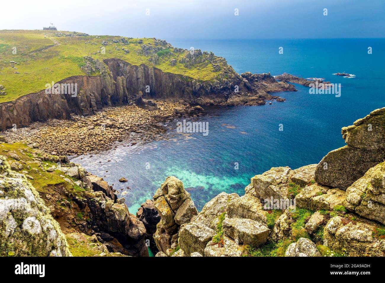 Cove and beach in Gwennap Head on the coast of Cornwall along the South West Coast Path with the National Coastwatch Institution in background, UK Stock Photo