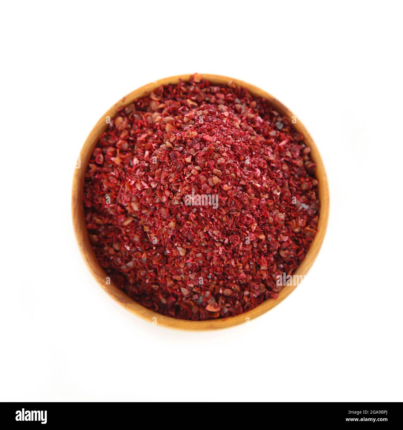 Sumac in wooden bowl, isolated on white Stock Photo Alamy
