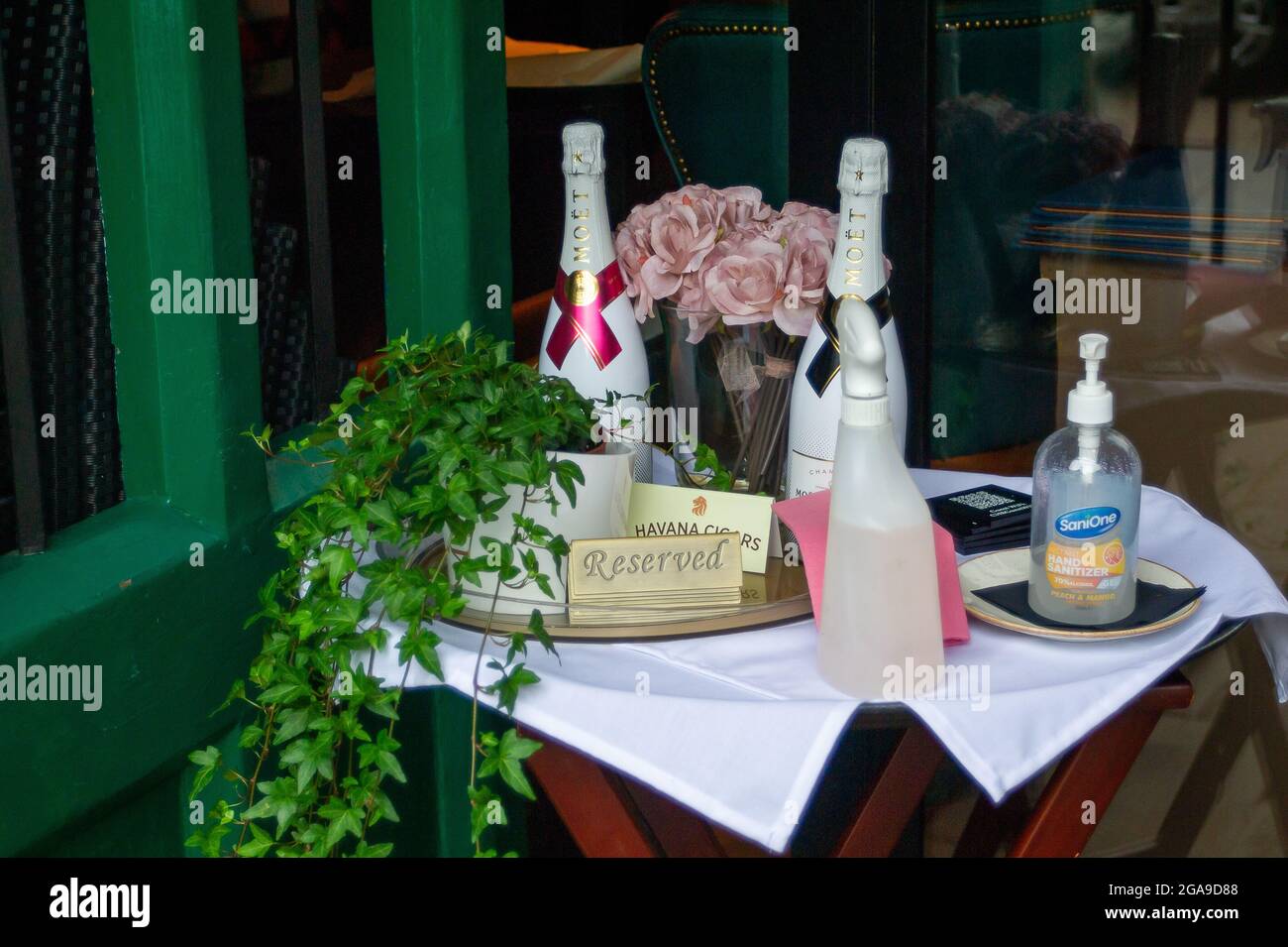 Berkhamsted, Hertfordshire, UK. 28th July, 2021. Champagne and hand sanitiser outside a restaurant. Credit: Maureen McLean/Alamy Stock Photo