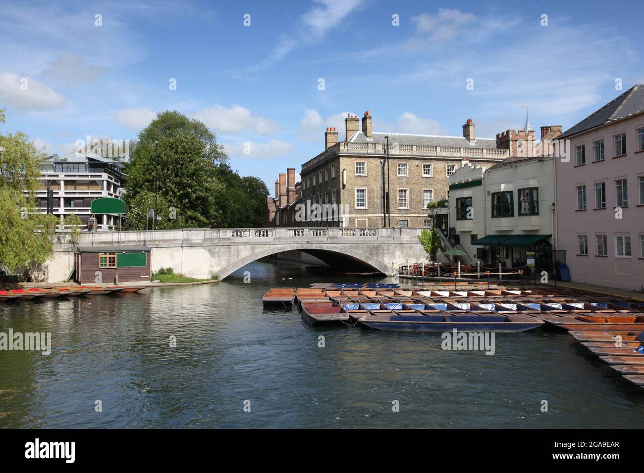 View of the river Cam in Cambridge complete with iconic punts tied at the side of the river waiting to hired. Stock Photo