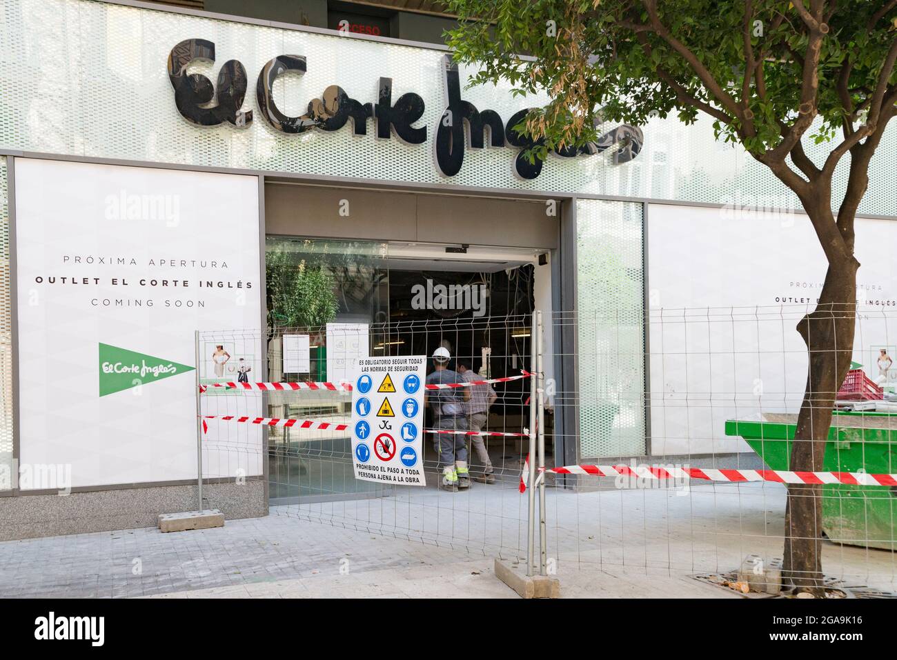 A woman walking by the El Corte Ingles department store under construction  for the upcoming outlet opening Stock Photo - Alamy