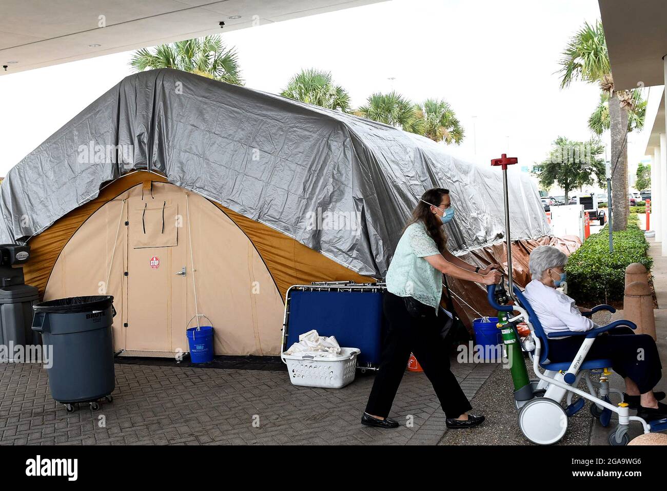 Melbourne, United States. 29th July, 2021. A patient is brought near a treatment tent outside the emergency department at Holmes Regional Medical Center in Melbourne. The tent was set up to serve as an overflow area as the number of COVID-19 infections surges throughout Brevard County, Florida due to the Delta variant and large numbers of unvaccinated residents. Credit: SOPA Images Limited/Alamy Live News Stock Photo