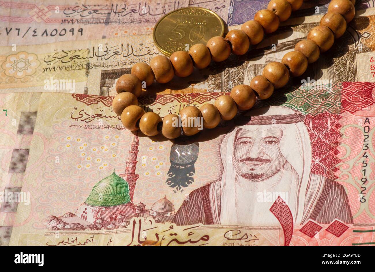 Top view of money, banknote and coin of Saudi Arabia Riyals and prayer beads, in shallow focus Stock Photo