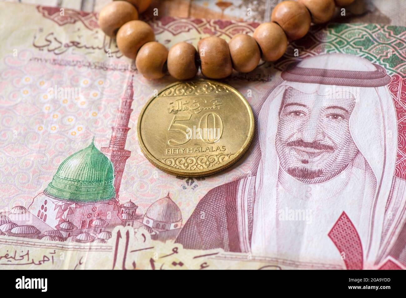 Top view of money, banknote and coin of Saudi Arabia Riyals and prayer beads, in shallow focus Stock Photo