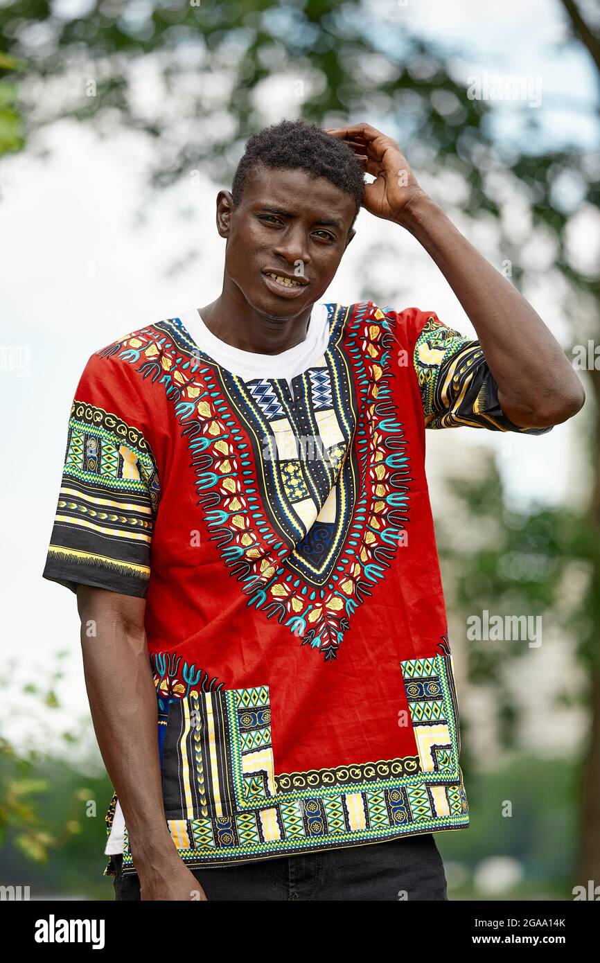 An African man in South African national clothes, a black young man resting in a park in national clothes Stock Photo