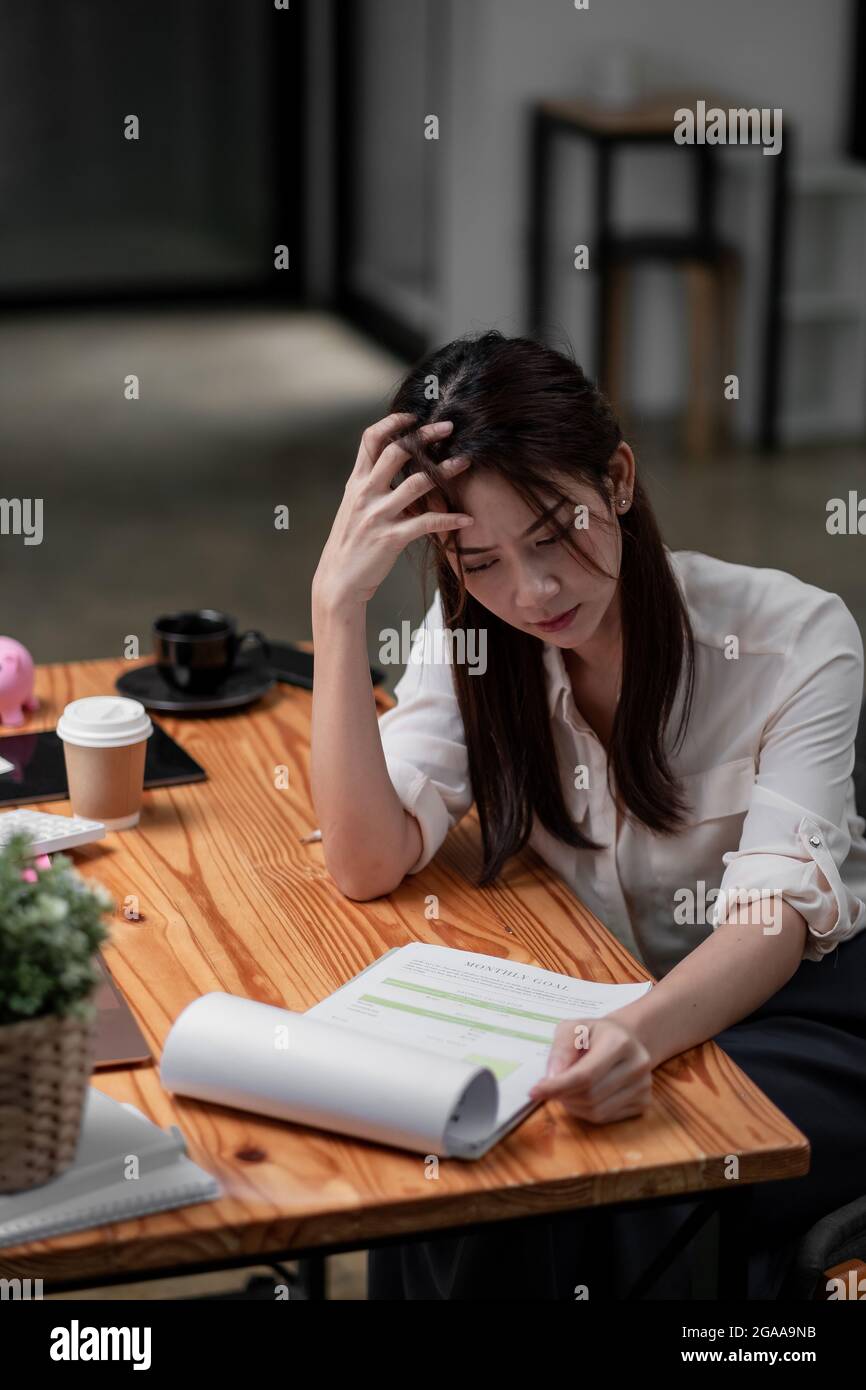 Stressed asian business woman working with marketing report. business financial concept. Stock Photo