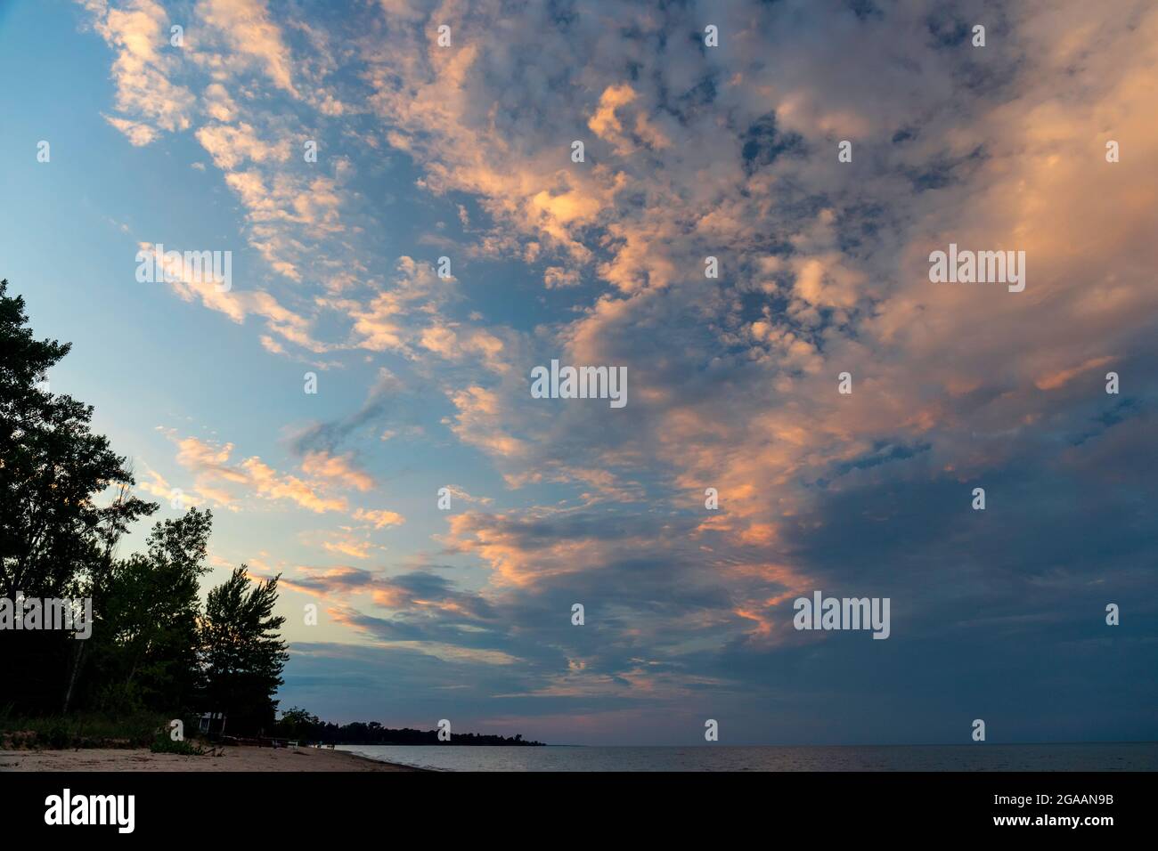 a group of sunset clouds in the sky over a great lake Stock Photo - Alamy