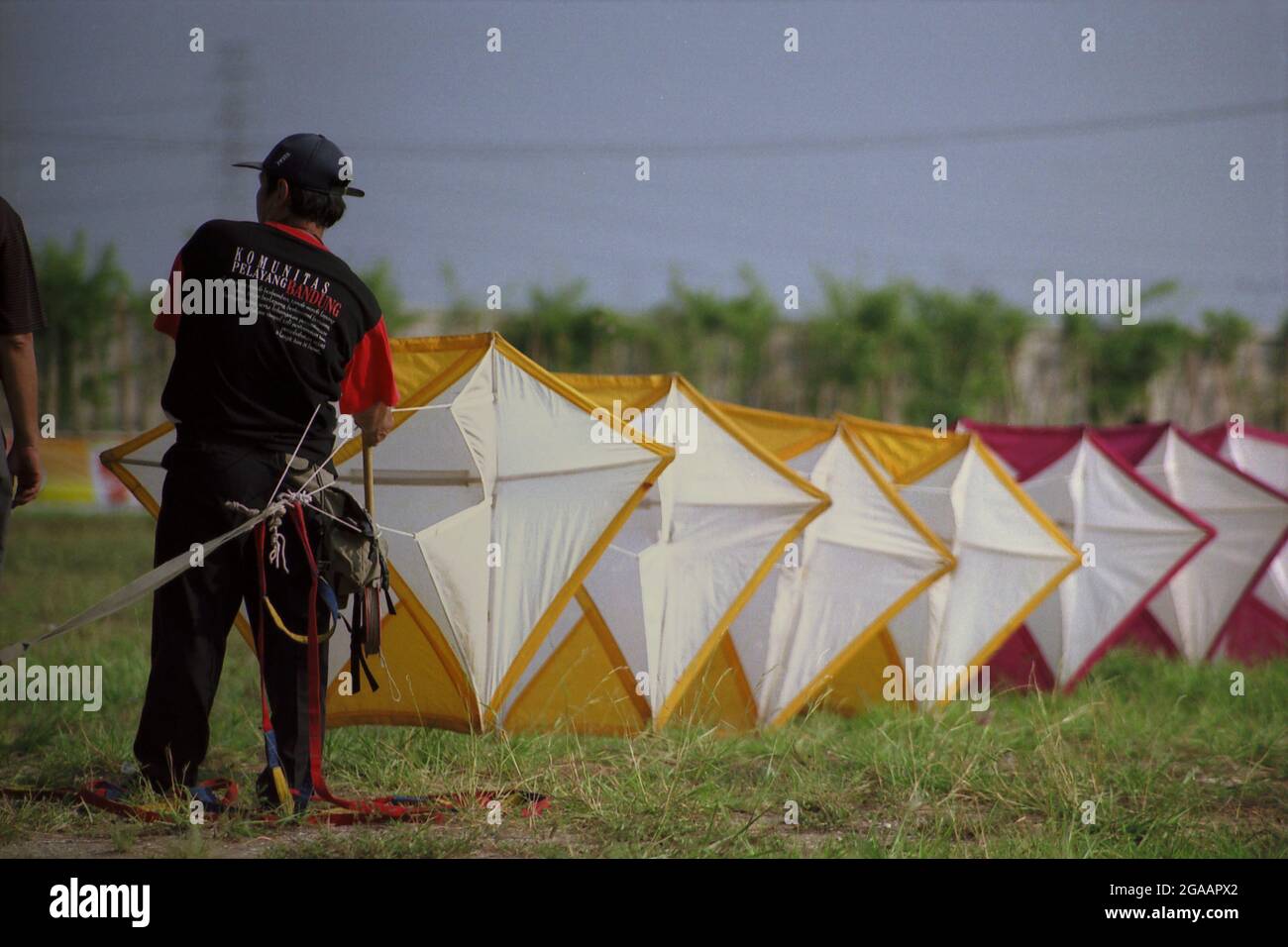 A man preparing a giant kite during the 2004 Jakarta International Kite Festival that held on July 9-11 at Carnival Beach in Ancol Dreamland, North Jakarta, Jakarta, Indonesia. Stock Photo
