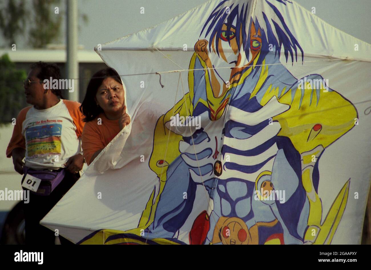 A woman holding a kite during the 2004 Jakarta International Kite Festival that held on July 9-11 at Carnival Beach in Ancol Dreamland, North Jakarta, Jakarta, Indonesia. Stock Photo