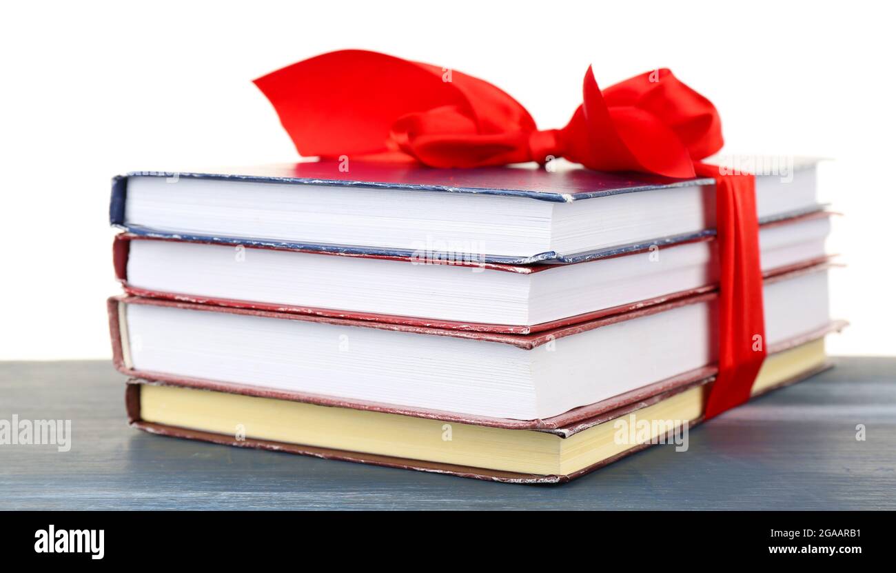 Stack of books with ribbon on table isolated on white Stock Photo - Alamy
