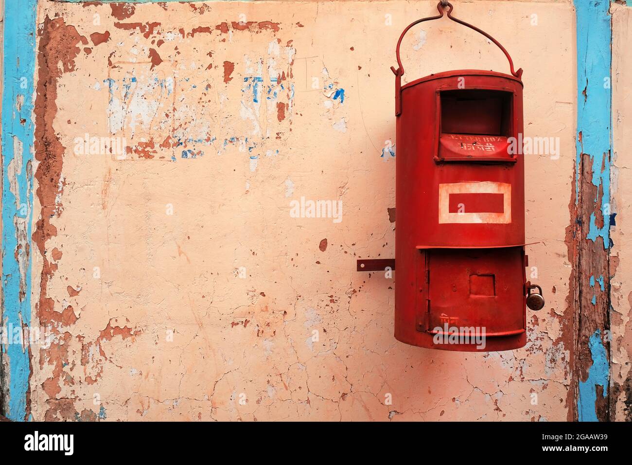 Traditional red color old Indian mailbox postbox Letter box on old textured wall. Stock Photo