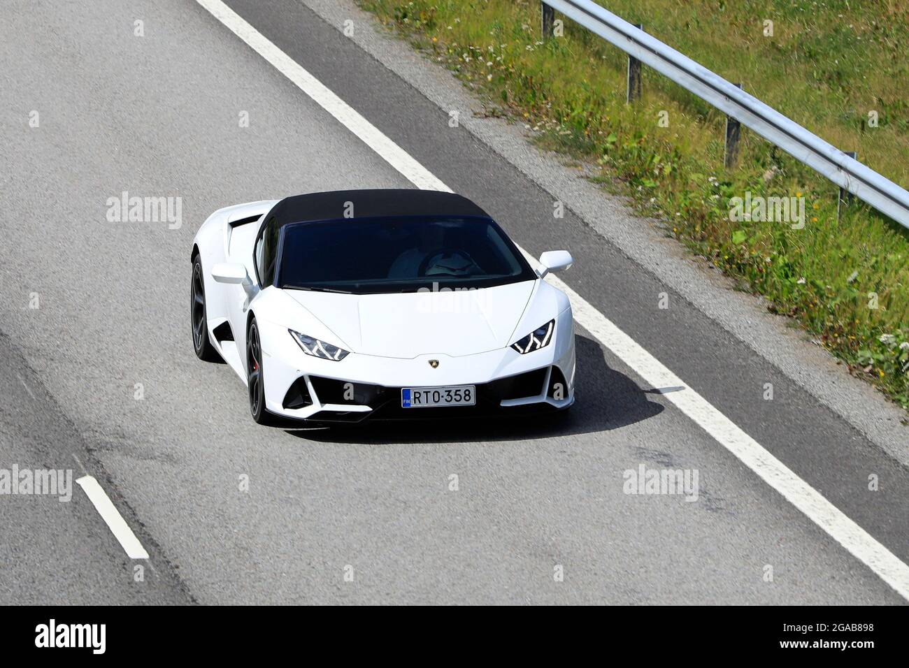 White Lamborghini Huracán LP 580-2 Spyder supercar at speed on motorway E18, elevated view. Salo, Finland. July 23, 2021. Stock Photo