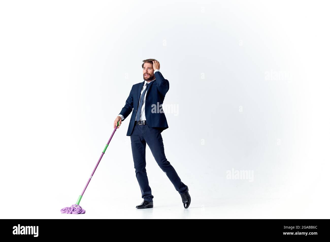 business man in a suit washes the floors with a mop manager Stock Photo