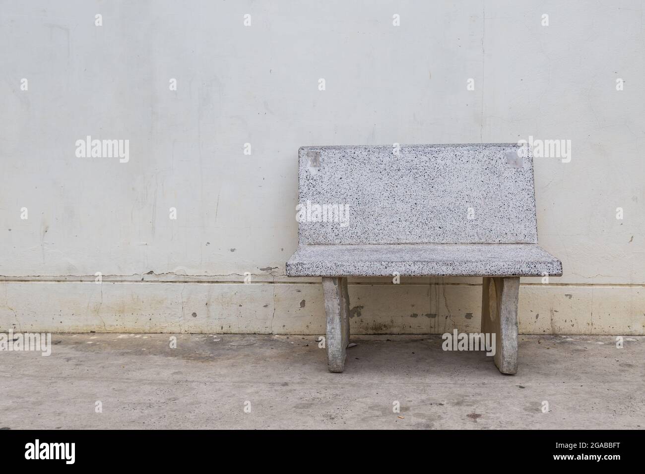 empty grungy old stone chair on cement wall blackground Stock Photo