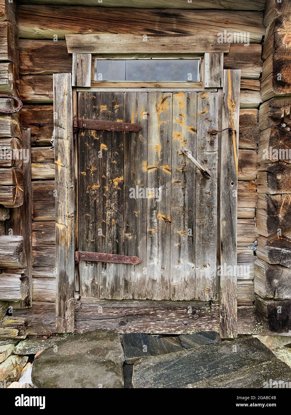 Weatherd worn wooden plank door of an old log house cabin Stock Photo