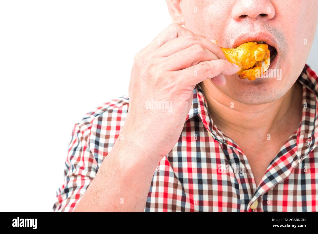 Man eating roasted chicken wings on white background Stock Photo