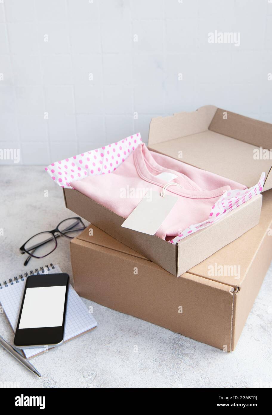 Clothes for kids in an open cardboard box. Online shopping concept