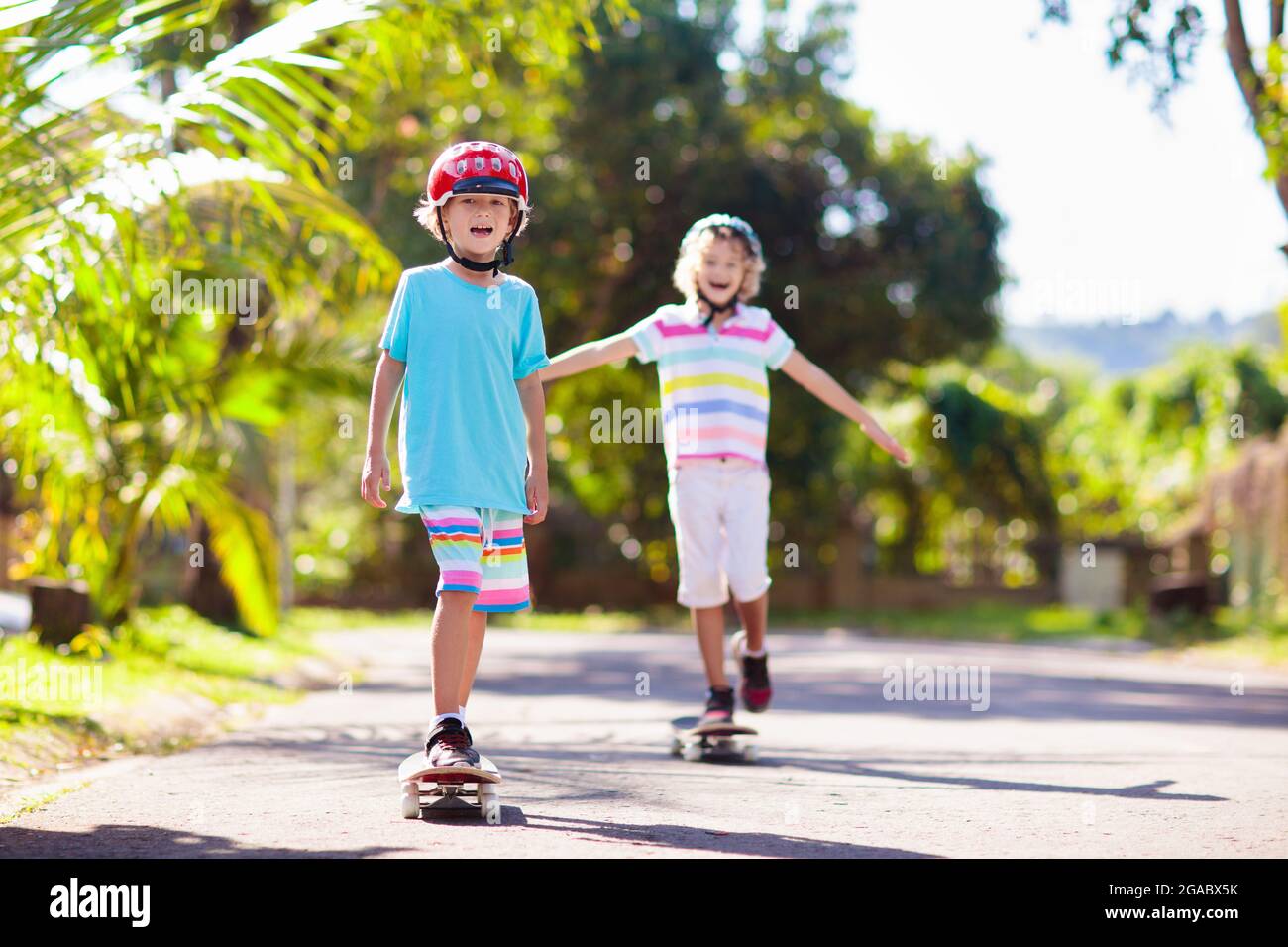 Kid with skateboard. Child riding skate board. Healthy sport and outdoor activity for school kids in summer. Sports fun. Helmet for safe exercise. Boy Stock Photo