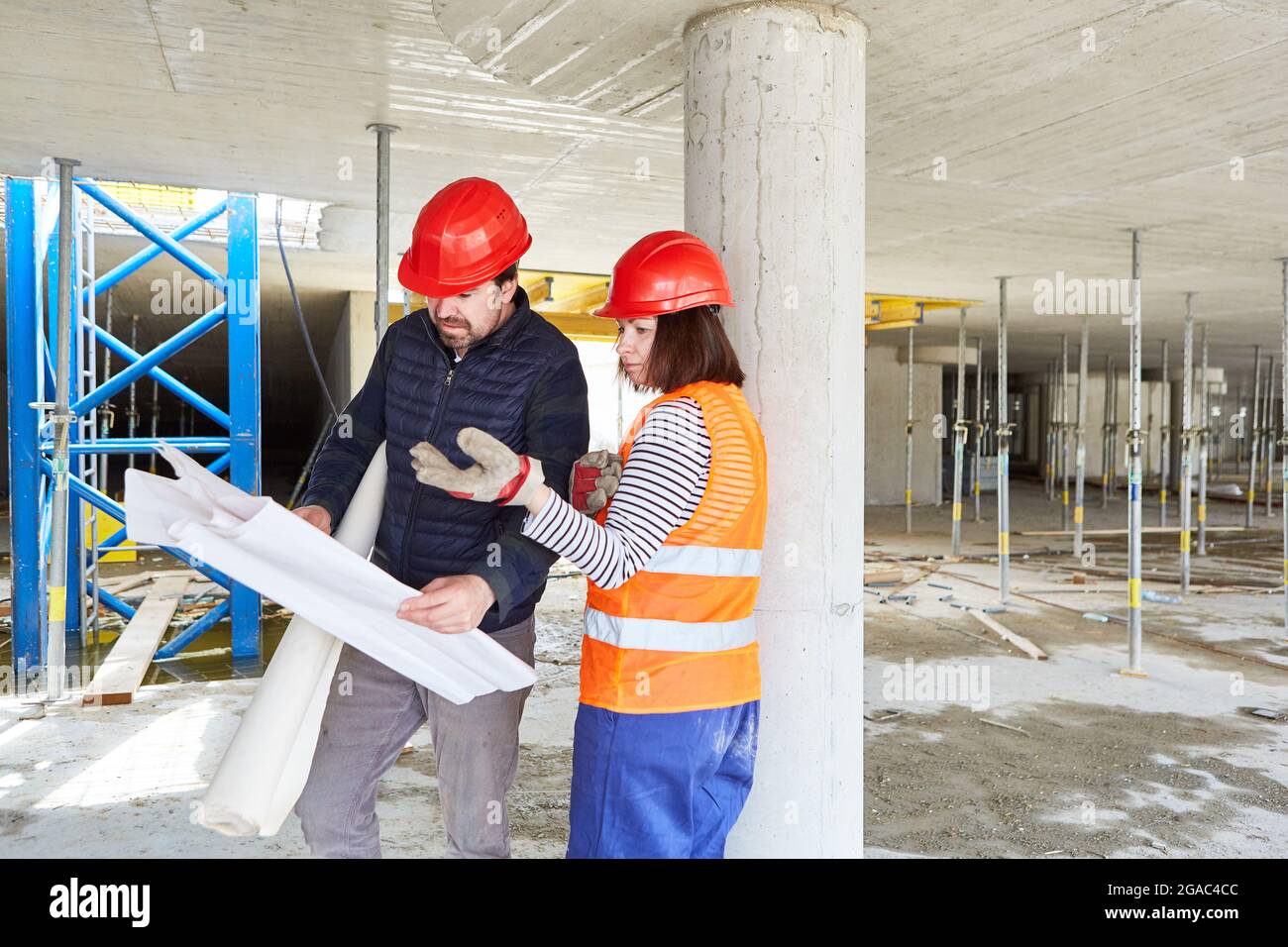 Architect and craftsman look at a construction plan together on a building site in the shell Stock Photo