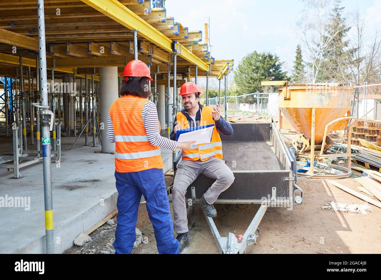 Workers team discusses construction project and construction planning on the construction site in the shell together Stock Photo