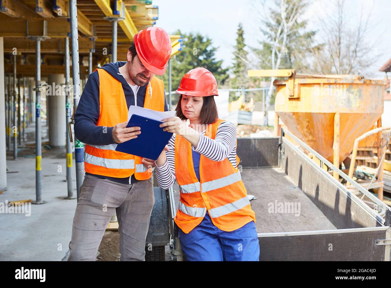 Worker and architect with checklist discuss the construction planning on the construction site together Stock Photo