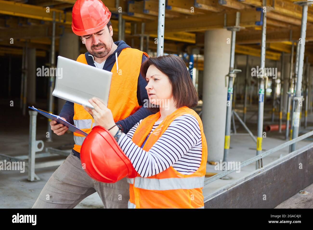 Architect with tablet computer and construction worker as foreman in front of the shell on the construction site Stock Photo