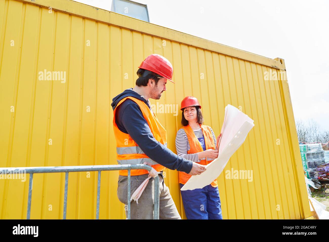 The architect and craftsman as foreman look together at a building plan for the house Stock Photo