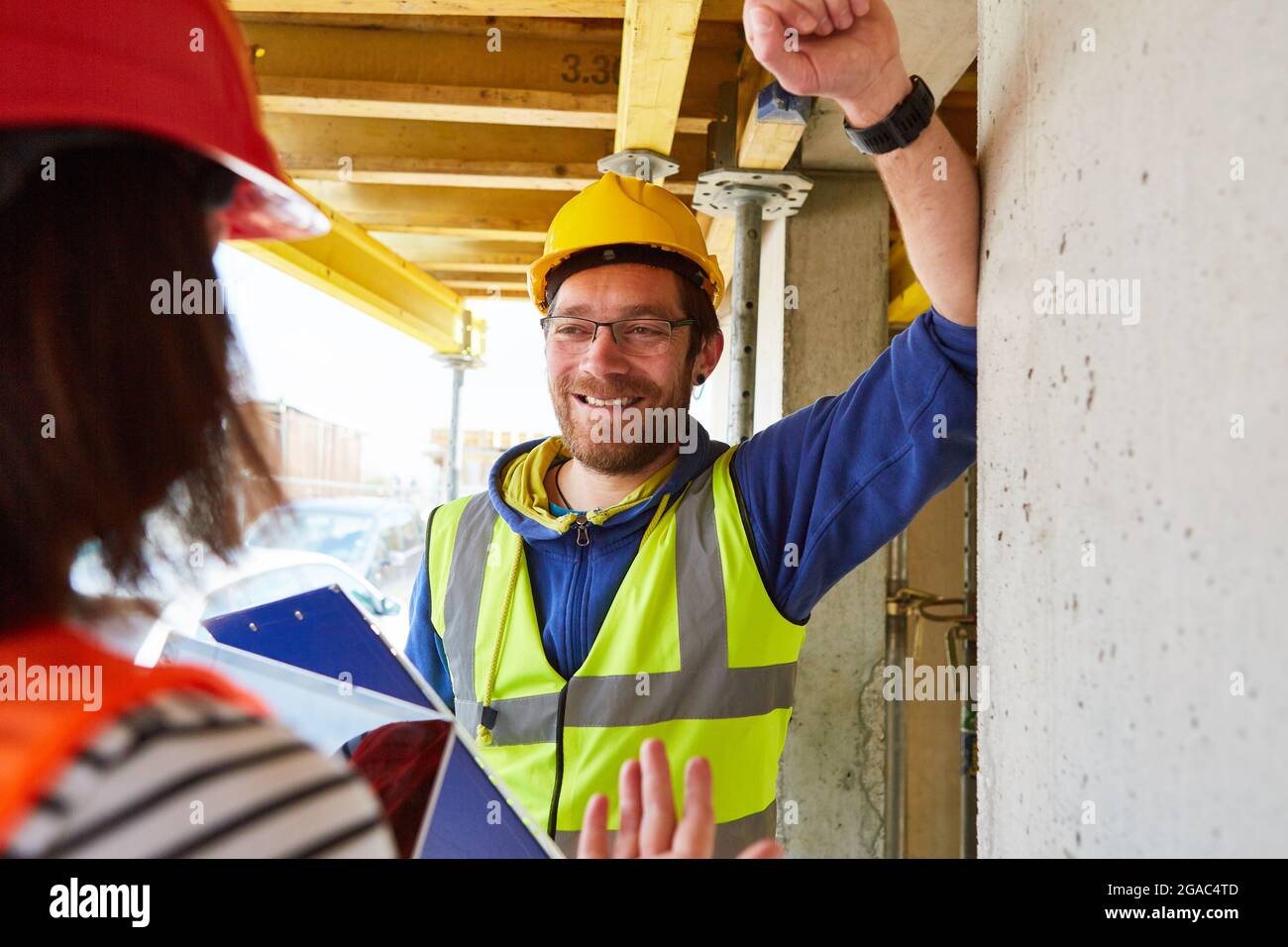 Smiling craftsman and architect on the construction site of house building discussing the construction project Stock Photo