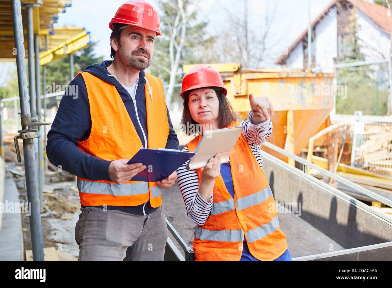 Architect with tablet computer and foreman with checklist during construction project planning Stock Photo