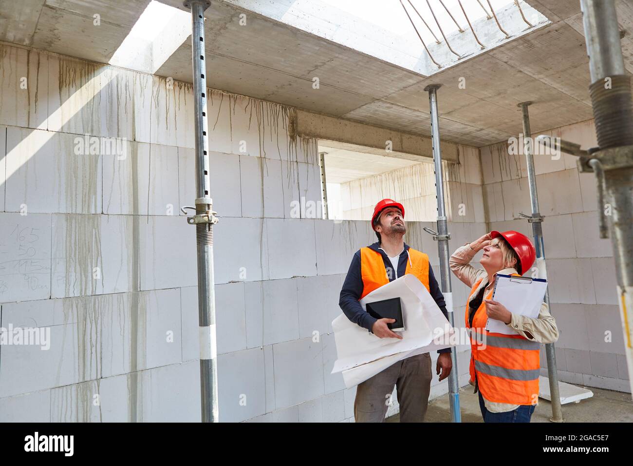 Construction expert and architect in the shell of a building site for house construction during an inspection Stock Photo