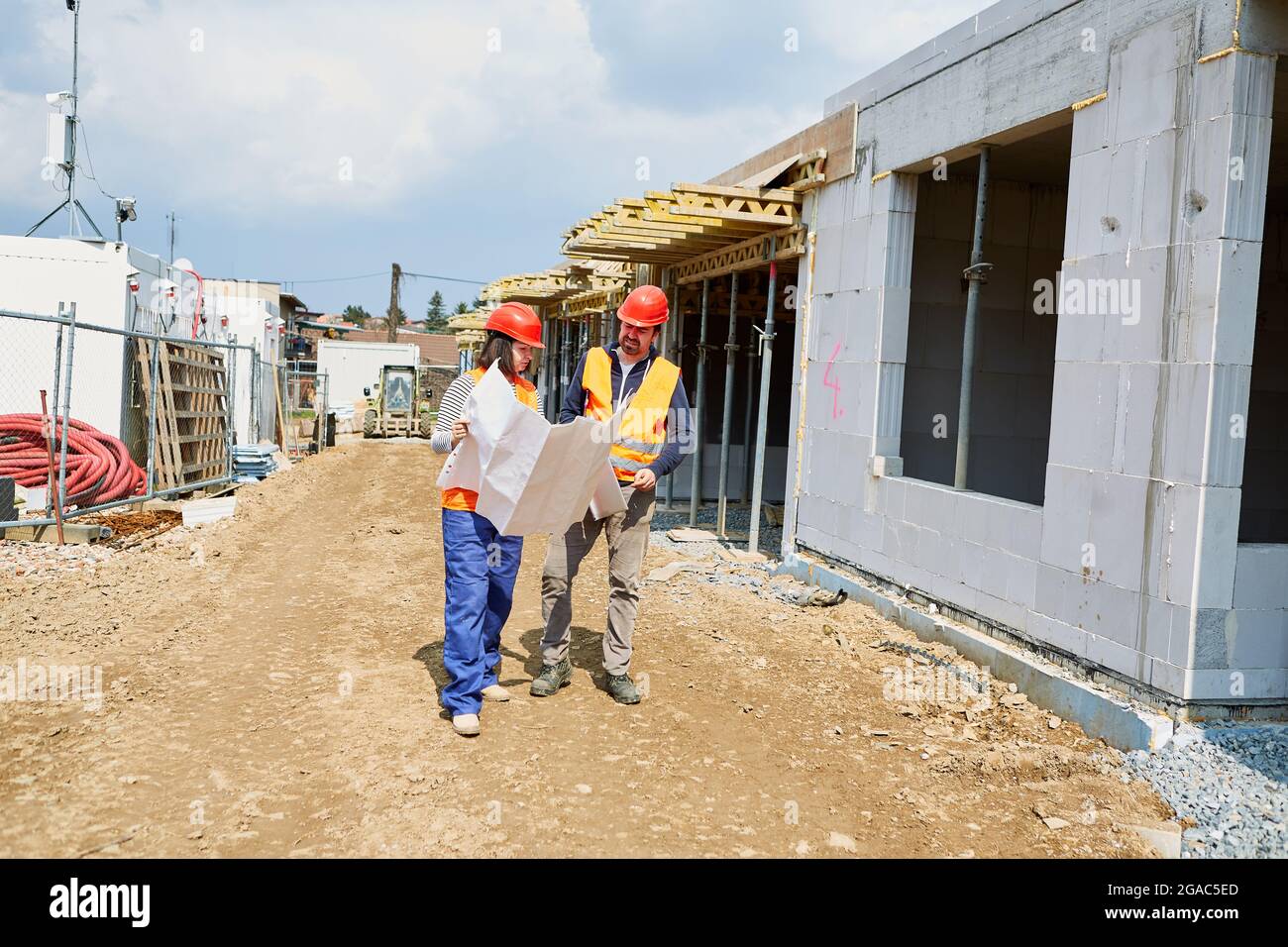 Architect and foreman with blueprint on the shell construction site when planning the construction project Stock Photo