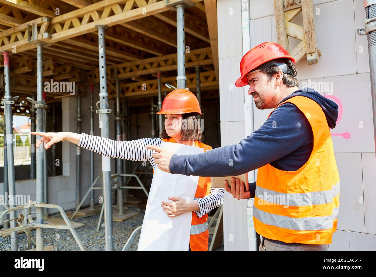 Architect and foreman during construction planning together before the shell of a construction site Stock Photo