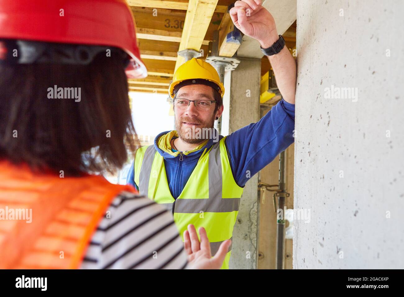 Craftsmen or construction workers and the architect discuss the construction project on the construction site Stock Photo