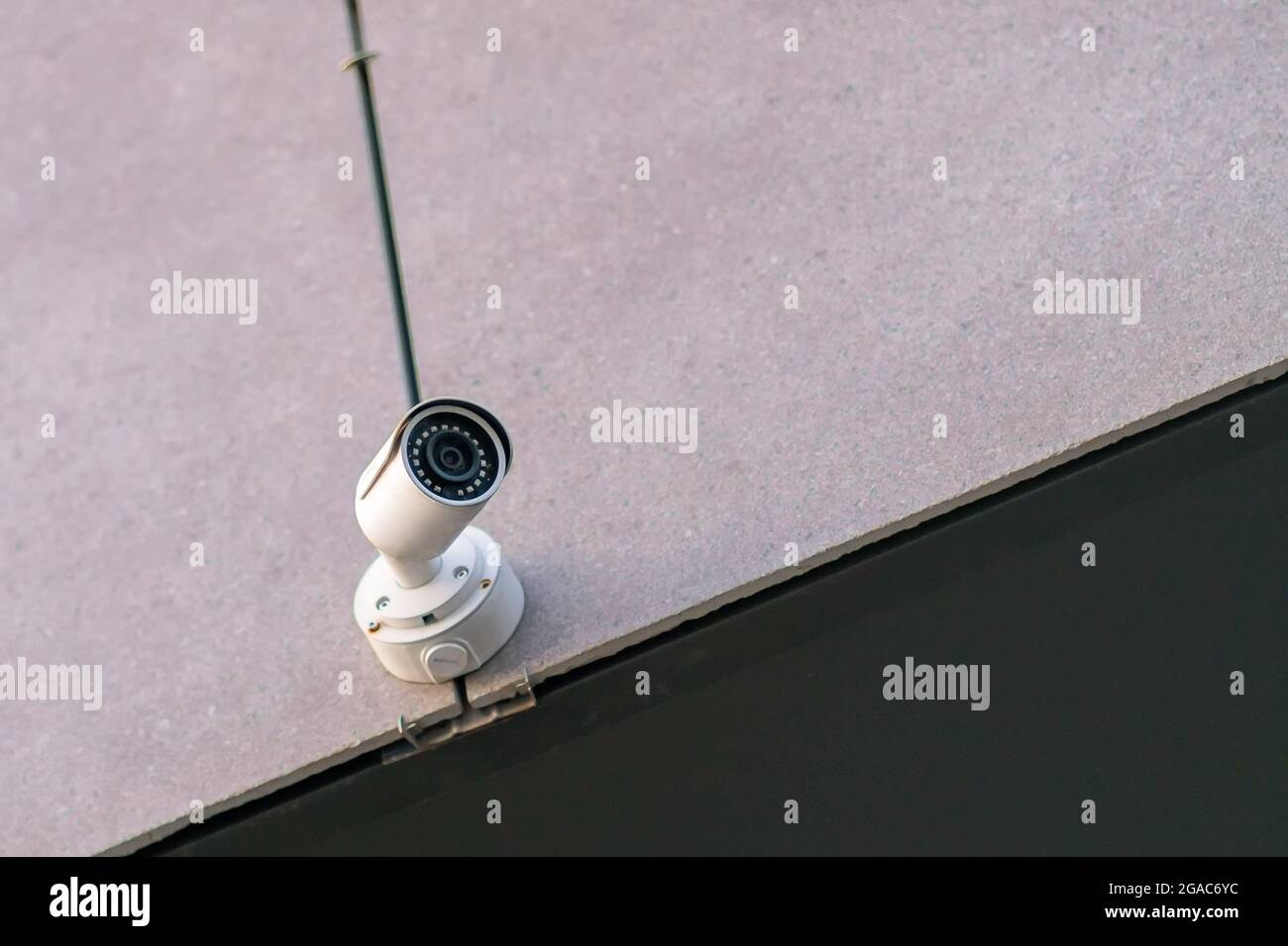 White CCTV camera on the wall with copy space Stock Photo