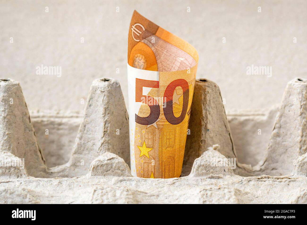 Fifty Euro bill in an egg cardboard box. Conceptual image. Stock Photo
