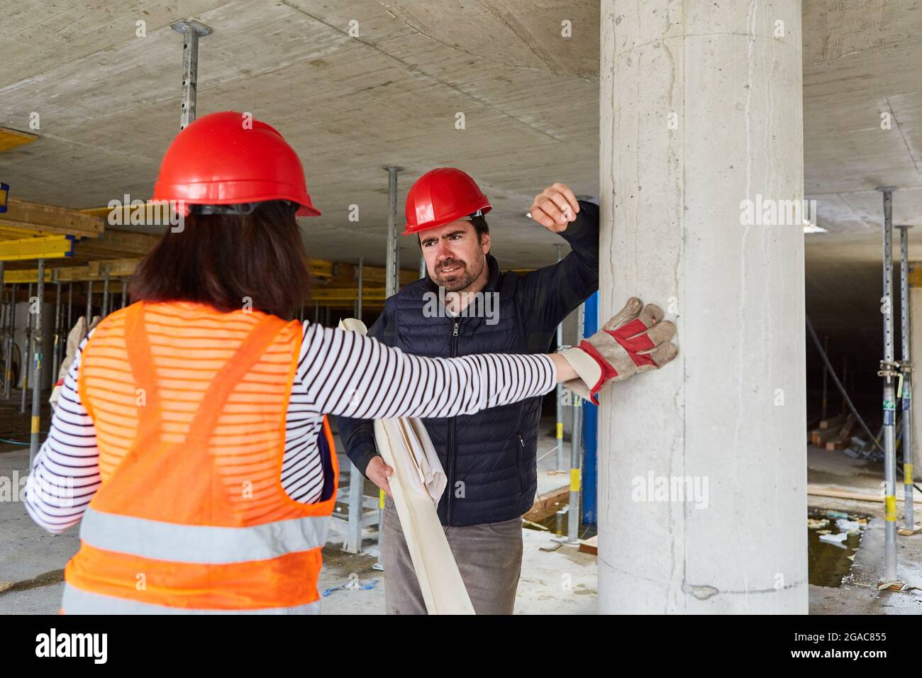 Architect and construction worker in the shell of the construction site when planning the work in the construction project Stock Photo