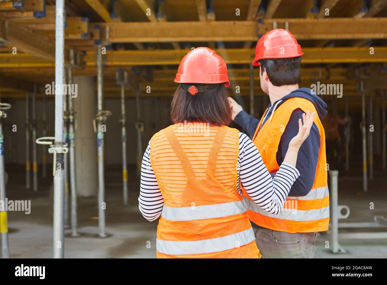 Architect and foreman or expert during an inspection of the shell of the construction site Stock Photo