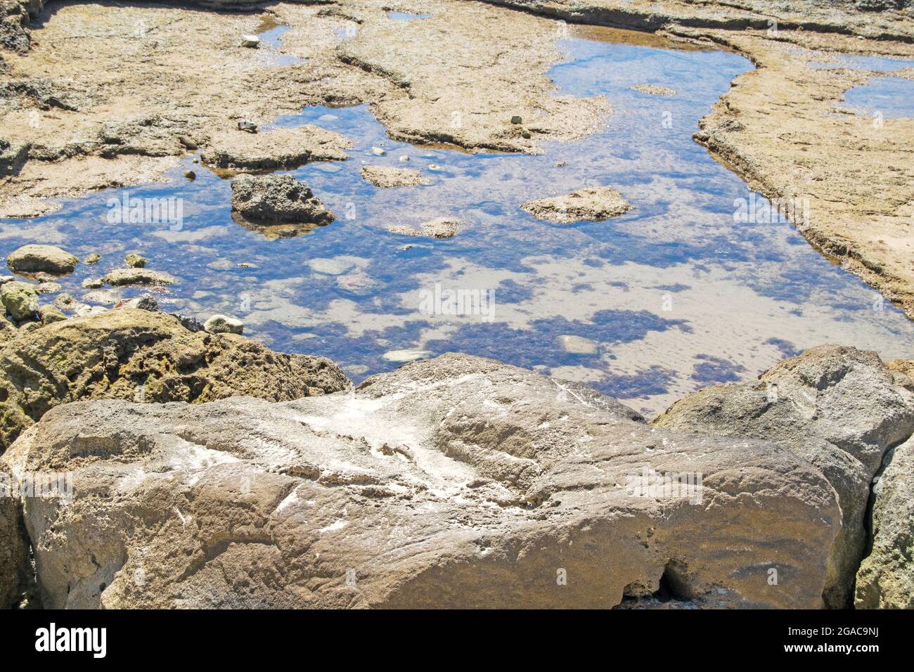 Large rocks with water as the tide goes down from the Playa de la Costilla in Rota, Cadiz, Andalusia, Spain Stock Photo