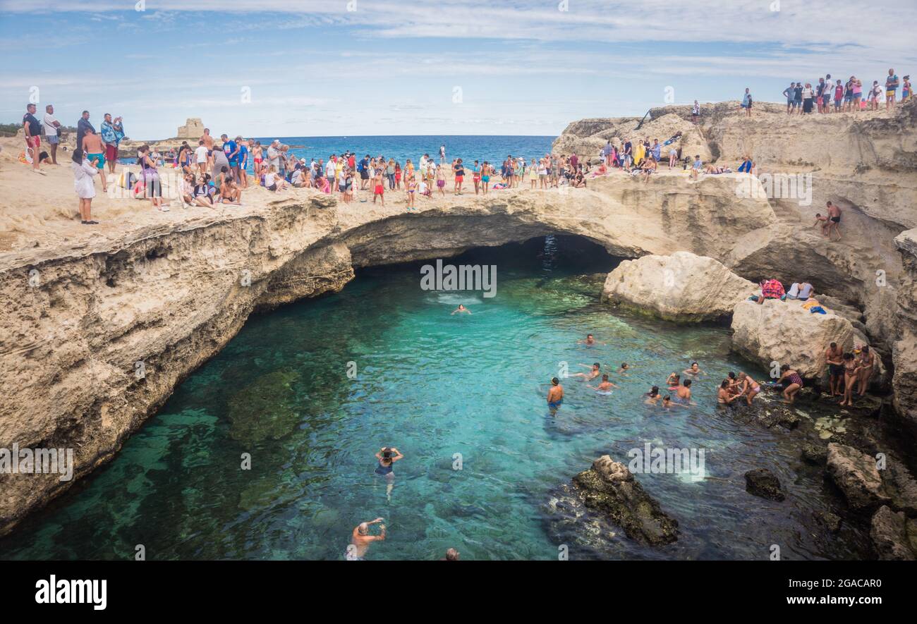 Grotta Della Poesia or Cave of Poetry. People swimming in a natural sea cave in Roca Vecchia on the Adriatic coastline, Apulia, Italy. Lecce, Italy - September 12, 2017 Stock Photo