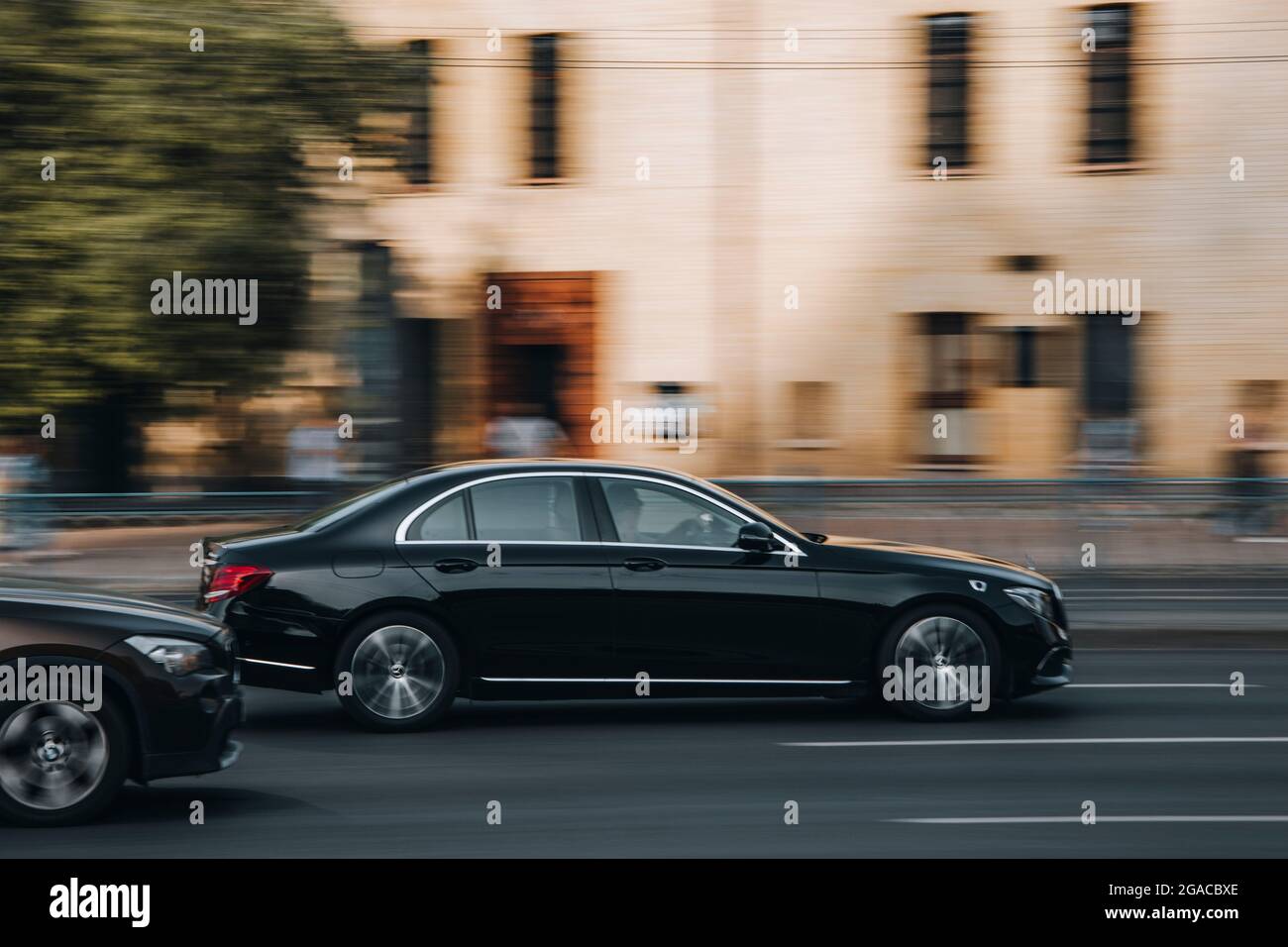 Ukraine, Kyiv - 16 July 2021: Black Mercedes-Benz E-Class AMG car moving on the street. Editorial Stock Photo