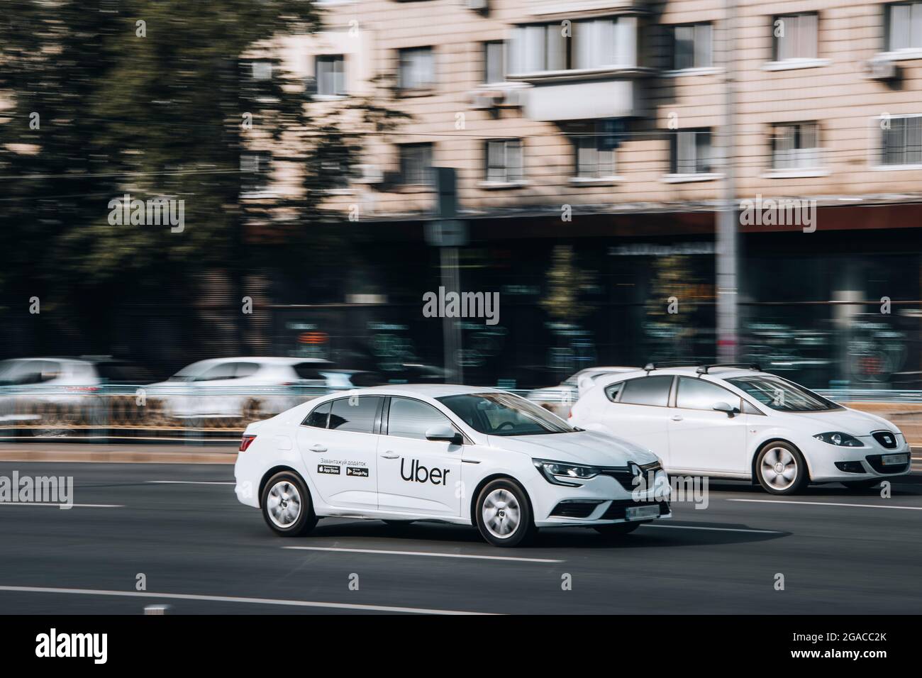 Ukraine, Kyiv - 16 July 2021: White Rnault Megane IV Taxi Uber car moving on the street. Editorial Stock Photo