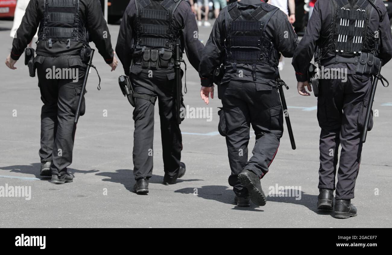 patrol of four policemen with truncheons and guns that control the city Stock Photo