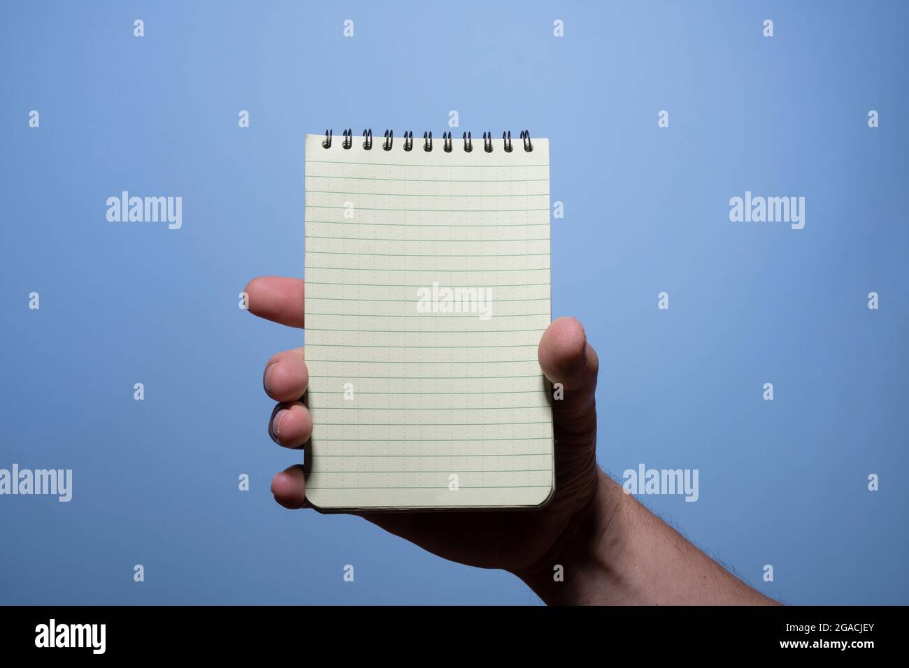 a notepad in a man's hand with the blue background Stock Photo