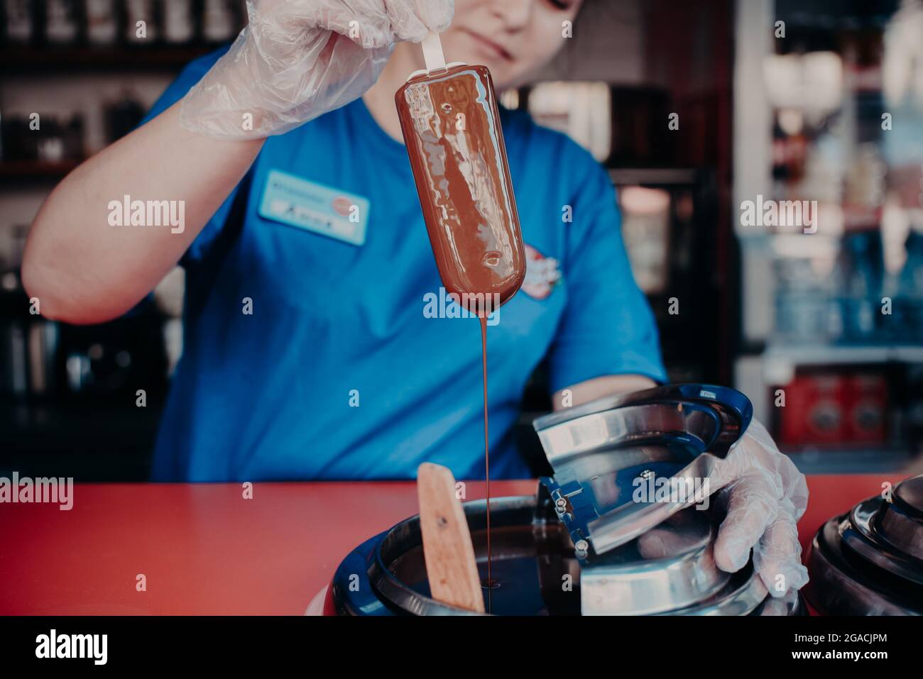 an ice cream vendor dips a popsicle in liquid chocolate Stock Photo Alamy