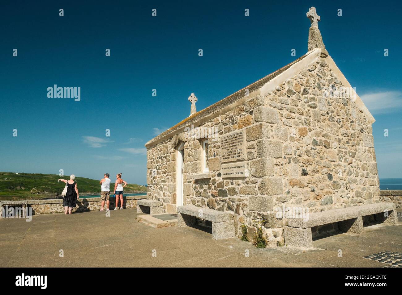 Visitors to the tiny St Nicholas' Chapel in St Ives, Cornwall enjoy the views from its elevated position. Stock Photo