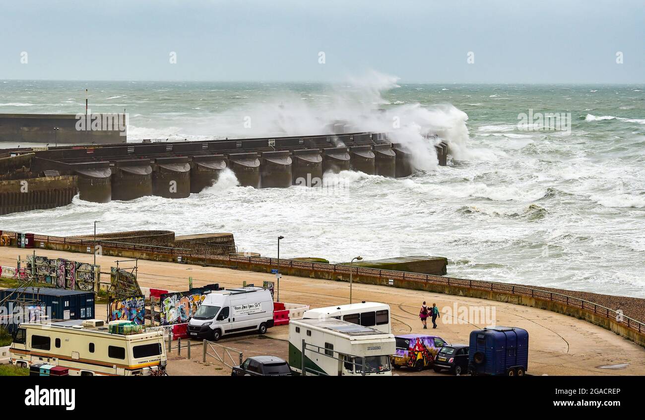 Brighton UK 30th July 2021 - Waves crash over Brighton Marina west wall as Storm Evert sweeps across the country with wind speeds forecast to be up to 60mph in some areas : Credit Simon Dack / Alamy Live News Stock Photo