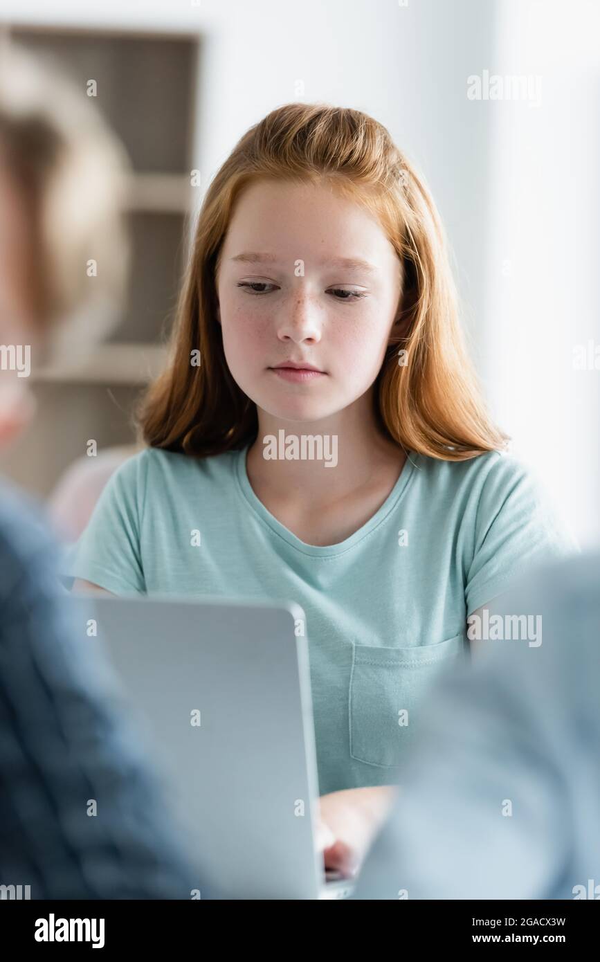 Teen schoolgirl using blurred laptop in classroom Stock Photo - Alamy